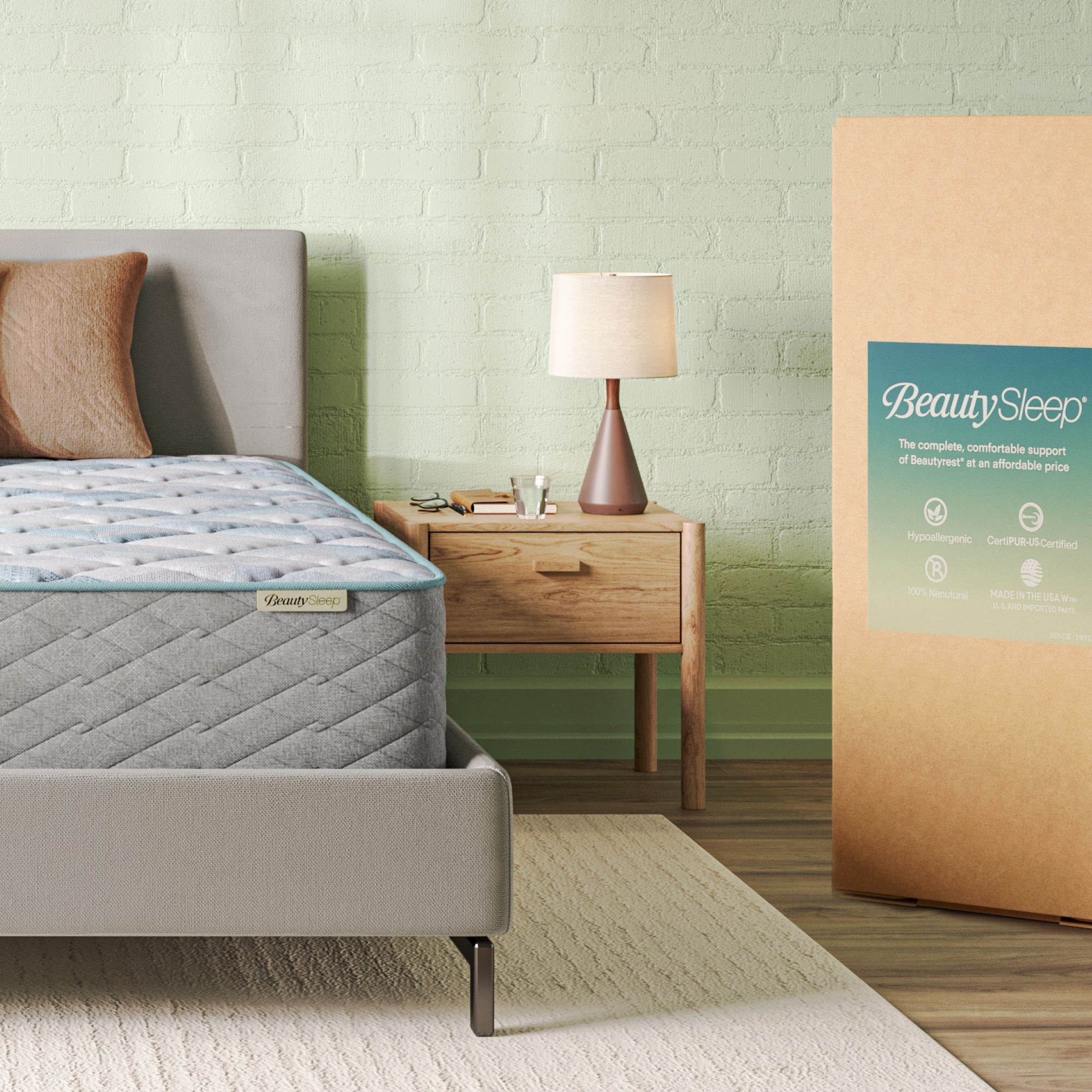 Beautysleep Mattress in a grey bedframe with 3 pillows on top of it within a bedroom setting with BeautySleep packaging to the right of it.