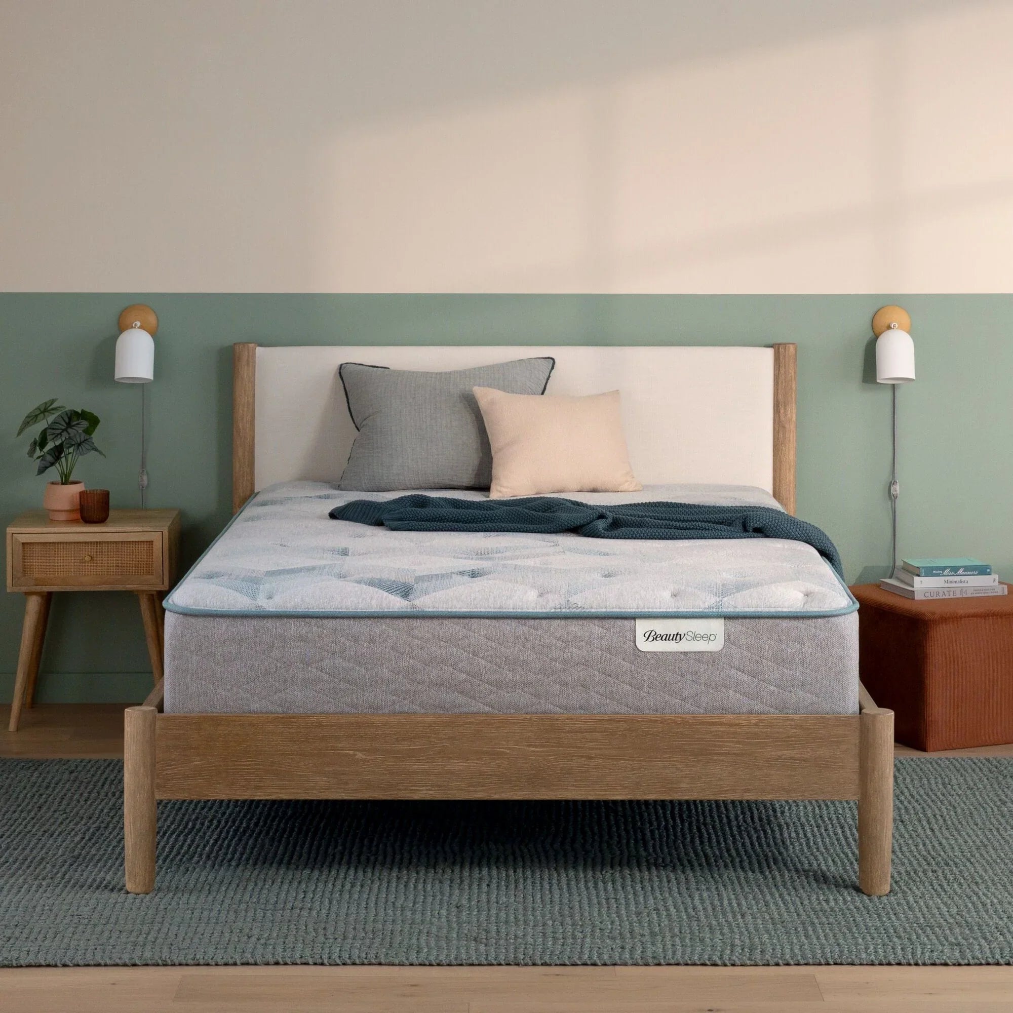 Beautysleep by Beautyrest mattress in a brown bedframe in a room setting with a lamp and nightstand.