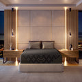 Modern bedroom with a Beautyrest Black Hybid XCS mattress in a beige bed frame and nightstands, featuring a brand logo on the mattress.