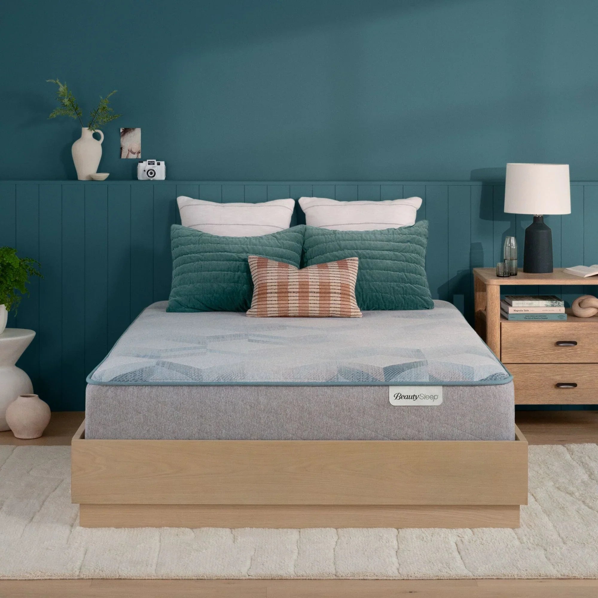 Beautysleep Mattress in a brown bedframe with 5 pillows on top of it within a bedroom setting