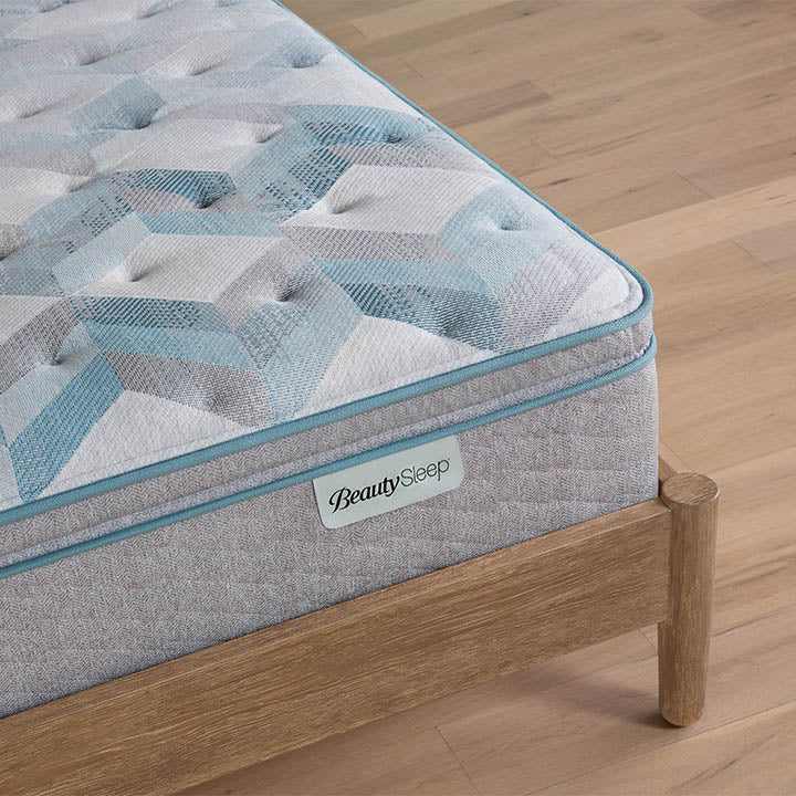 Beautysleep by Beautyrest mattress Gray quilted mattress on a wooden bed frame with 'BeautySleep' branding.